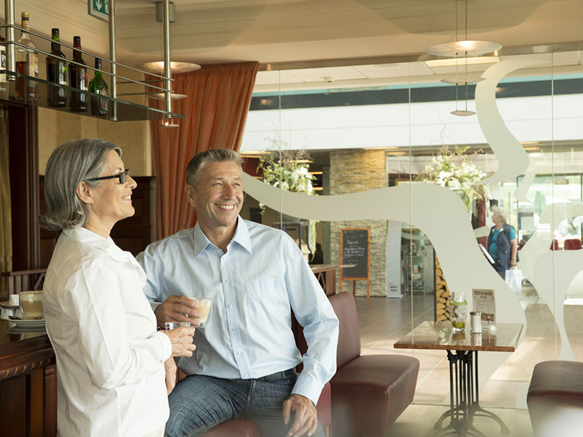 Ein Mann und eine Frau unterhalten sich an der Bar des Wiener Cafés